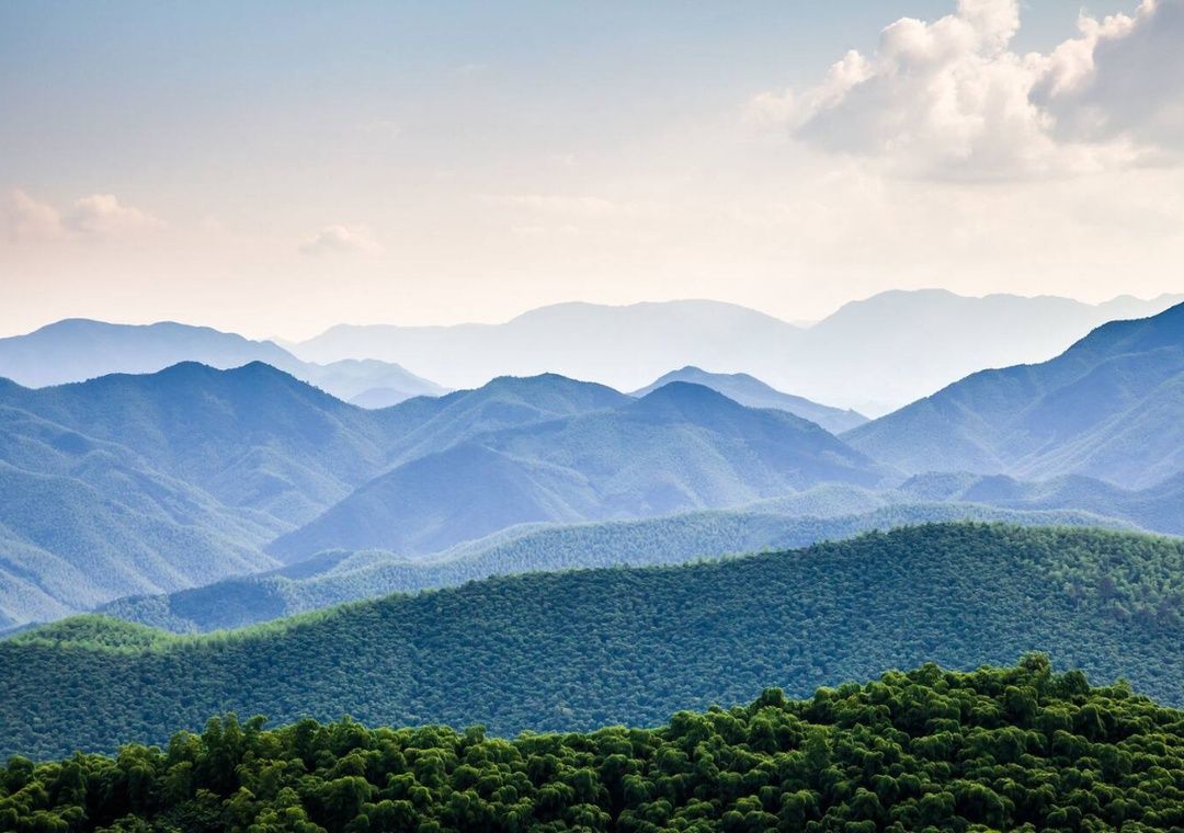 Layered Smoky Mountain ridges under a bright sky